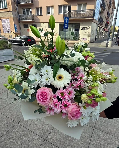 Bukiet okolicznościowy biało-różowy: Biało-różowy bukiet okolicznościowy z różami, gerberą, chryzantemami, liliami, eustomą i eukaliptusem, ułożony w jasnym papierze. Kwiaciarnia Bukieteria Gorzów Wielkopolski